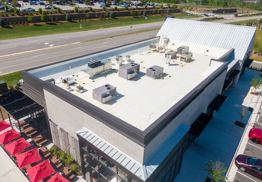 Drone view of rooftop HVAC units on a flat TPO commercial roof
